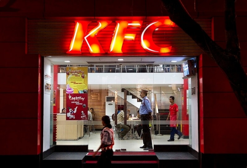 A pedestrian walks past a KFC restaurant in Kolkata, India